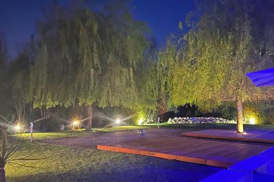 Salle de réception décorée avec des tables rondes, nappes blanches, serviettes orange et centres de table floraux.