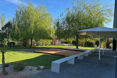 Salle de réception décorée avec des tables rondes, nappes blanches, serviettes orange et centres de table floraux.