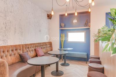 Salle lumineuse avec parquet en chevrons, murs décorés de bleu et blanc, et mobilier moderne en bois clair.