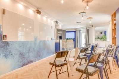 Salle lumineuse avec parquet en chevrons, murs décorés de bleu et blanc, et mobilier moderne en bois clair.