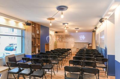 Salle lumineuse avec parquet en chevrons, murs décorés de bleu et blanc, et mobilier moderne en bois clair.