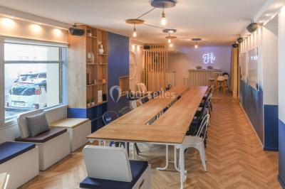 Salle lumineuse avec parquet en chevrons, murs décorés de bleu et blanc, et mobilier moderne en bois clair.