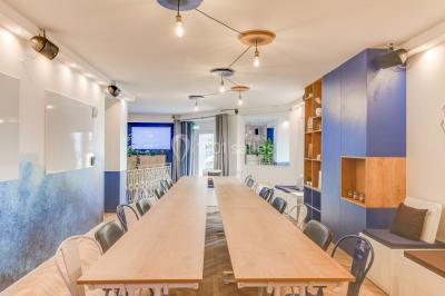 Salle lumineuse avec parquet en chevrons, murs décorés de bleu et blanc, et mobilier moderne en bois clair.