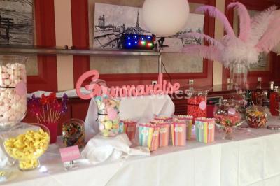 Gâteau de mariage à quatre étages décoré de rubans beige clair, posé sur un présentoir blanc.