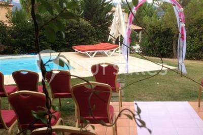 Gâteau de mariage à quatre étages décoré de rubans beige clair, posé sur un présentoir blanc.