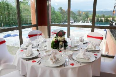Gâteau de mariage à quatre étages décoré de rubans beige clair, posé sur un présentoir blanc.