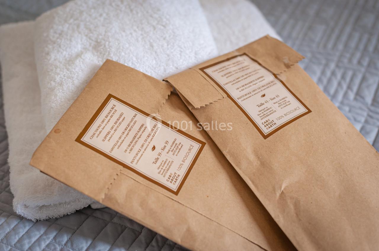 Deux sachets en papier kraft posés sur une serviette blanche, sur une couverture matelassée grise.