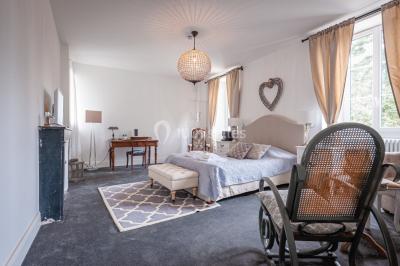 Deux lits simples avec tête de lit noire, coussins jaunes, et tableaux d'animaux anthropomorphes au mur.