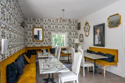 Deux lits simples avec tête de lit noire, coussins jaunes, et tableaux d'animaux anthropomorphes au mur.