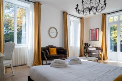 Deux lits simples avec tête de lit noire, coussins jaunes, et tableaux d'animaux anthropomorphes au mur.