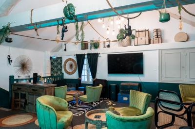 Deux lits simples avec tête de lit noire, coussins jaunes, et tableaux d'animaux anthropomorphes au mur.