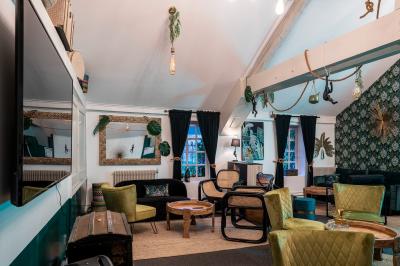 Deux lits simples avec tête de lit noire, coussins jaunes, et tableaux d'animaux anthropomorphes au mur.