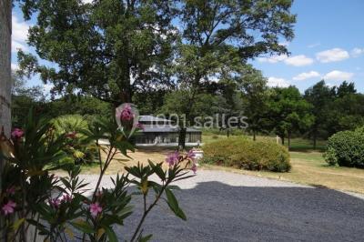 Salle de bain avec baignoire sur pieds, douche vitrée, lavabo, toilettes et carrelage beige décoré de motifs floraux.