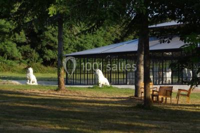 Salle de bain avec baignoire sur pieds, douche vitrée, lavabo, toilettes et carrelage beige décoré de motifs floraux.