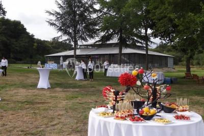 Salle de bain avec baignoire sur pieds, douche vitrée, lavabo, toilettes et carrelage beige décoré de motifs floraux.