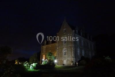 Salle de bain avec baignoire sur pieds, douche vitrée, lavabo, toilettes et carrelage beige décoré de motifs floraux.