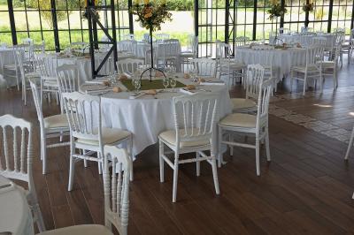 Salle de bain avec baignoire sur pieds, douche vitrée, lavabo, toilettes et carrelage beige décoré de motifs floraux.