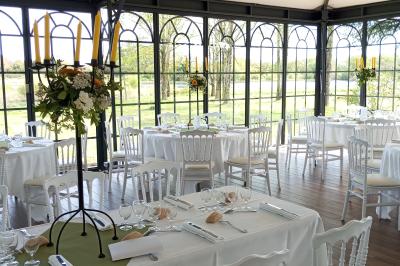 Salle de bain avec baignoire sur pieds, douche vitrée, lavabo, toilettes et carrelage beige décoré de motifs floraux.
