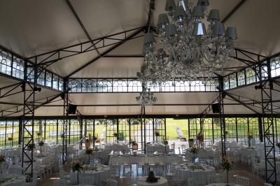 Salle de bain avec baignoire sur pieds, douche vitrée, lavabo, toilettes et carrelage beige décoré de motifs floraux.