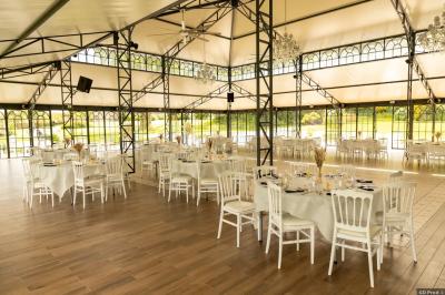 Salle de bain avec baignoire sur pieds, douche vitrée, lavabo, toilettes et carrelage beige décoré de motifs floraux.
