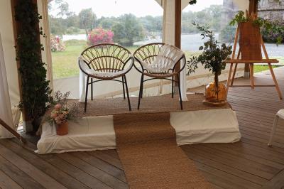 Salle de bain avec baignoire sur pieds, douche vitrée, lavabo, toilettes et carrelage beige décoré de motifs floraux.