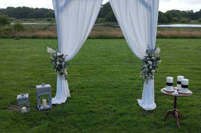 Salle de bain avec baignoire sur pieds, douche vitrée, lavabo, toilettes et carrelage beige décoré de motifs floraux.