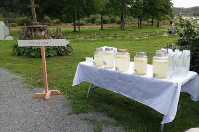 Salle de bain avec baignoire sur pieds, douche vitrée, lavabo, toilettes et carrelage beige décoré de motifs floraux.