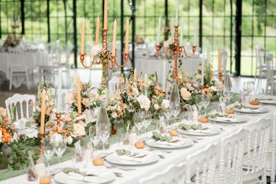 Salle de bain avec baignoire sur pieds, douche vitrée, lavabo, toilettes et carrelage beige décoré de motifs floraux.