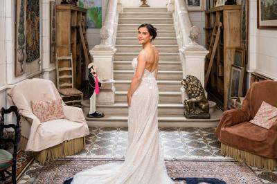 Salle de bain avec baignoire sur pieds, douche vitrée, lavabo, toilettes et carrelage beige décoré de motifs floraux.