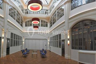 Plafond en verrière d'une galerie intérieure, laissant entrer la lumière naturelle sous un ciel dégagé.