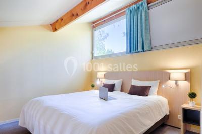 Des personnes allongées sur des transats sous des parasols, profitant du soleil près d'une piscine.