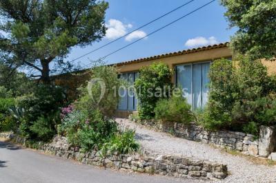 Des personnes allongées sur des transats sous des parasols, profitant du soleil près d'une piscine.