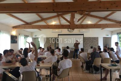 Des personnes allongées sur des transats sous des parasols, profitant du soleil près d'une piscine.