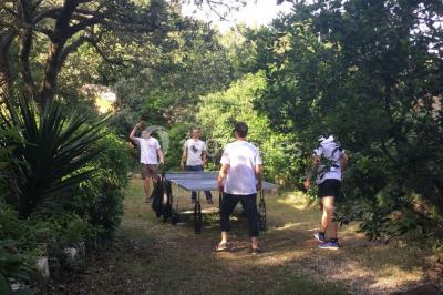 Des personnes allongées sur des transats sous des parasols, profitant du soleil près d'une piscine.