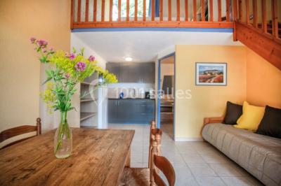 Des personnes allongées sur des transats sous des parasols, profitant du soleil près d'une piscine.