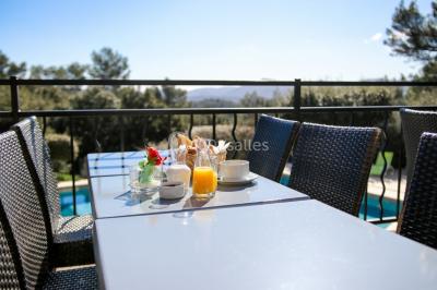Des personnes allongées sur des transats sous des parasols, profitant du soleil près d'une piscine.