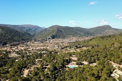 Des personnes allongées sur des transats sous des parasols, profitant du soleil près d'une piscine.
