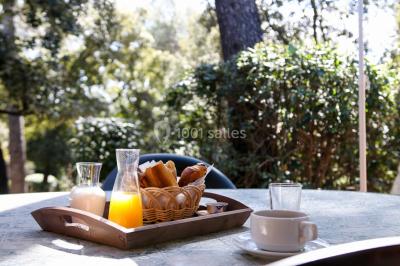 Des personnes allongées sur des transats sous des parasols, profitant du soleil près d'une piscine.