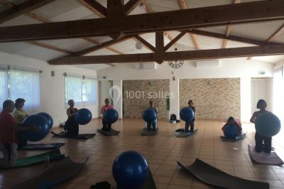 Des personnes allongées sur des transats sous des parasols, profitant du soleil près d'une piscine.