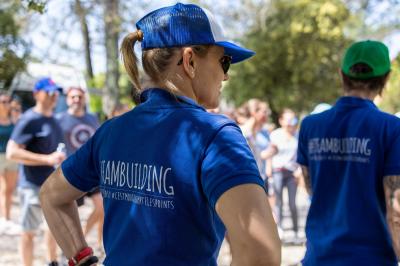 Des personnes allongées sur des transats sous des parasols, profitant du soleil près d'une piscine.