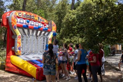Des personnes allongées sur des transats sous des parasols, profitant du soleil près d'une piscine.