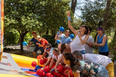 Des personnes allongées sur des transats sous des parasols, profitant du soleil près d'une piscine.