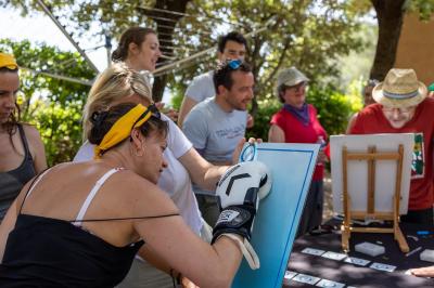 Des personnes allongées sur des transats sous des parasols, profitant du soleil près d'une piscine.