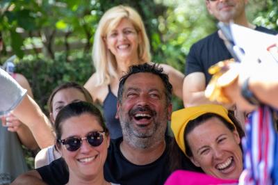 Des personnes allongées sur des transats sous des parasols, profitant du soleil près d'une piscine.