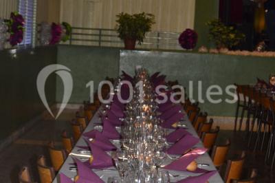 Aire de jeux extérieure avec toboggan, balançoires et structures en bois, entourée de pelouse et d'arbres.