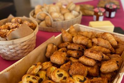Bâtiment moderne éclairé la nuit, entouré d'un espace extérieur sombre avec un ciel nuageux en arrière-plan.