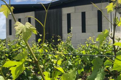 Bâtiment moderne éclairé la nuit, entouré d'un espace extérieur sombre avec un ciel nuageux en arrière-plan.