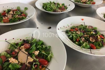 Bâtiment moderne éclairé la nuit, entouré d'un espace extérieur sombre avec un ciel nuageux en arrière-plan.