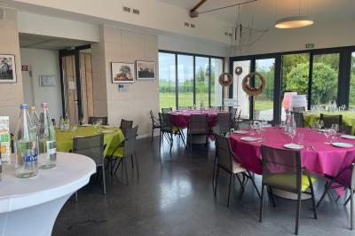 Bâtiment moderne éclairé la nuit, entouré d'un espace extérieur sombre avec un ciel nuageux en arrière-plan.