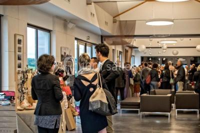Bâtiment moderne éclairé la nuit, entouré d'un espace extérieur sombre avec un ciel nuageux en arrière-plan.